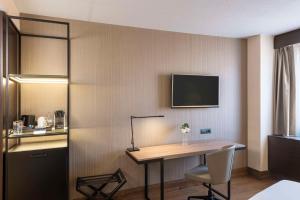 Uma TV ou centro de entretenimento em NH Geneva Airport Hotel