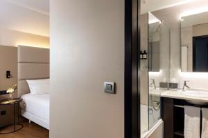 Cama ou camas em um quarto em NH Geneva Airport Hotel