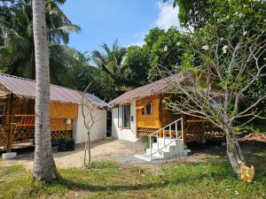 a house with a palm tree in front of it at Srithanu Haus in Haad Chao Phao