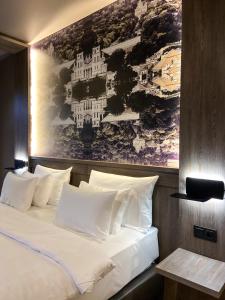 a bed in a room with a painting on the wall at CONTI HOTEL VILNIUS, Conference Centre, Restaurant & Bar in Vilnius