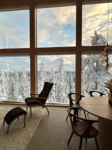a room with a view of snow covered trees through a window at Aamunkoi Skyview Villas A in Syöte