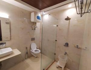 a bathroom with a shower with a toilet and a sink at The Kenilworth Mussoorie by Stotrak On Mall Road with On-site Parking in Mussoorie