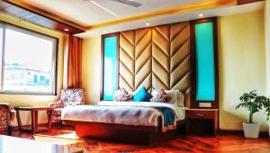 a bedroom with a bed and a large window at The Kenilworth Mussoorie by Stotrak On Mall Road with On-site Parking in Mussoorie +34 photos