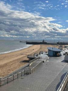 a view of a beach with a pier and the ocean at Ramsgate Harbour Retreat in Kent