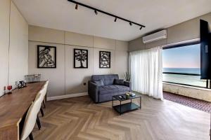 a living room with a couch and a table at Blue Suite in Netanya