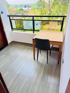 a balcony with a wooden table and a chair at Les Résidences Terre Royale in Sokouhoué