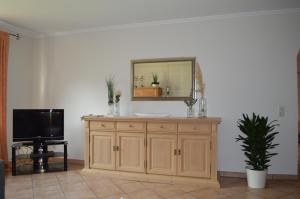 a wooden dresser with a mirror and a tv at Ferienwohnung am Maienbach in Bad Bramstedt
