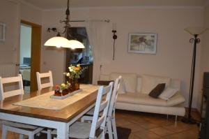 a living room with a table and a couch at Ferienwohnung am Maienbach in Bad Bramstedt +5 photos