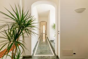 a hallway with a staircase in a building with plants at Villa Torre del Sasso in Marina Porto +17 photos
