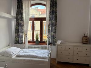 a bedroom with a bed and a window with curtains at Apartament Deptak Sądecki in Nowy Sącz