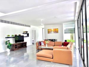 a living room with a couch and a tv at VILLA 5 BED ROOMS SANCTUARY HỒ TRÀM ll Private Beach ll BBQ in Xuyên Mộc
