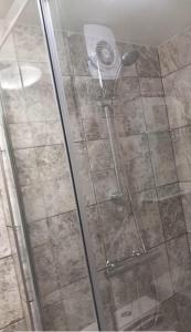 a shower with a glass door in a bathroom at 3 Guests - 1 Bedroom in Erith +10 photos