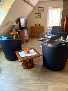 a living room with blue chairs and a table at L Atypik à L ancienne forge in Muhlbach-sur-Munster
