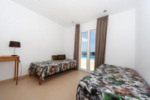 sypialnia z 2 łóżkami i oknem z widokiem na ocean w obiekcie Ficula Nou Beachfront Villa with private pool w mieście Punta Grossa +37 zdjęć