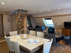 a living room with a table and chairs and a ladder at L Atypik à L ancienne forge in Muhlbach-sur-Munster