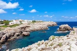 Skalisty brzeg z domami i oceanem w obiekcie Ficula Nou Beachfront Villa with private pool w mieście Punta Grossa