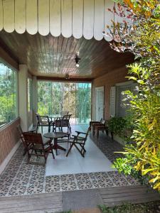 eine Terrasse mit Tischen und Stühlen auf einem Haus in der Unterkunft Casa Flor de Gravatá in Gravatá