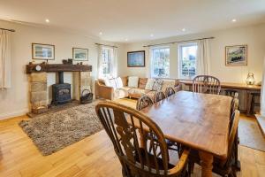 ein Wohnzimmer mit einem Holztisch und einem Kamin in der Unterkunft Host & Stay - Newton Cottage in Alnwick + 19 Fotos
