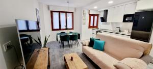 a living room with a couch and a table and a kitchen at La Zancuda in Alcalá de Henares