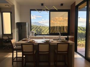 a kitchen with a table with chairs and a refrigerator at Solarium Mantiqueira 2 - Cinema e vistas incríveis in Itanhandu