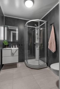 a bathroom with a shower and a sink and a toilet at Modern 1-room apartment - right by the Arctic Cathedral and Fjellheisen in Tromsø