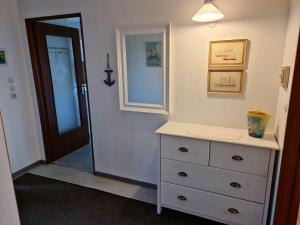 y baño con tocador blanco y espejo. en Haus Schlüter, en Utersum
