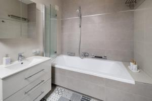 a white bathroom with a tub and a sink at Uhu Villa 750 m2 - Budapest in Budapest