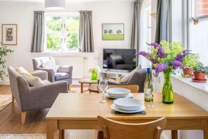 ノリッジにあるSwift Host - 1 Bedroom House - Beautiful - Garden - Free Parking - Close to Centreの花瓶付きのテーブルのあるリビングルーム