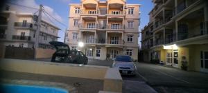 two cars parked in a parking lot in front of buildings at LKH Appt Adam Garden Villa in Grand Baie