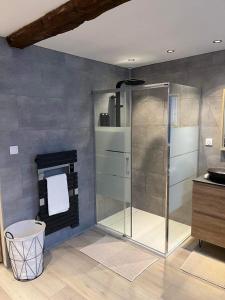 a bathroom with a shower with a glass door at Le Bonhomique in Seclin