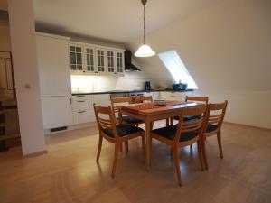a kitchen with a wooden table and chairs at Gut Rattelvitz, Galerie F WEST in Gingst