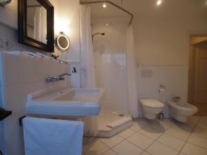 a bathroom with a sink and a toilet at Gut Rattelvitz, Galerie F WEST in Gingst