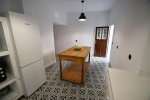 a room with a wooden table and a refrigerator at La Esquina del Castillo - A 15 min de Puy Du Fou in Orgaz +21 photos