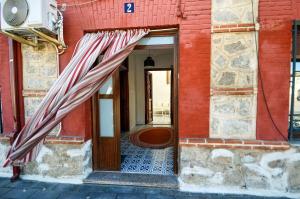 a red building with an open door with an umbrella at La Esquina del Castillo - A 15 min de Puy Du Fou in Orgaz