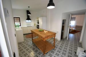 a kitchen with a wooden table in a room at La Esquina del Castillo - A 15 min de Puy Du Fou in Orgaz