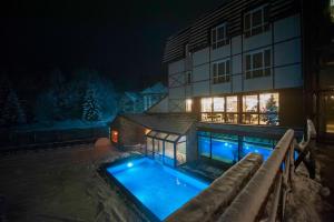 a house with a swimming pool at night at Hotel Kraljevi Čardaci in Kopaonik