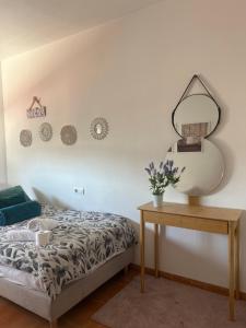 a bedroom with a bed and a mirror and a table at Evens-Goretti House in Mairena del Aljarafe