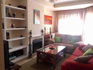 ein Wohnzimmer mit einem roten Sofa und einem Kamin in der Unterkunft Amplio adosado a 5 mits del metro y centro comercial in Mairena del Aljarafe