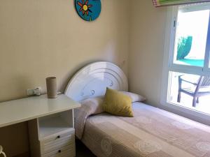 ein Schlafzimmer mit einem Bett und einer Uhr an der Wand in der Unterkunft Amplio adosado a 5 mits del metro y centro comercial in Mairena del Aljarafe