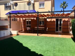 eine Terrasse mit grünem Rasen vor einem Haus in der Unterkunft Amplio adosado a 5 mits del metro y centro comercial in Mairena del Aljarafe