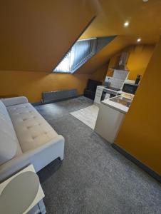 an attic room with a bed and a kitchen at Harrington House Apartment in Grimsby +4 photos