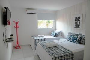 a white room with two beds and a couch at Casa da árvore com 5 suítes in Cabo de Santo Agostinho +32 photos