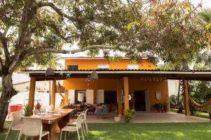 a table and chairs in front of a house at Casa da árvore com 5 suítes in Cabo de Santo Agostinho