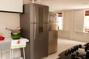 a kitchen with a large stainless steel refrigerator at Casa da árvore com 5 suítes in Cabo de Santo Agostinho