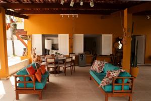 a living room with a couch and a table and chairs at Casa da árvore com 5 suítes in Cabo de Santo Agostinho