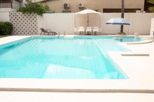 a large swimming pool with blue tiles on it at Casa da árvore com 5 suítes in Cabo de Santo Agostinho
