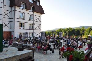 a crowd of people sitting outside of a building at Hotel Kraljevi Čardaci in Kopaonik