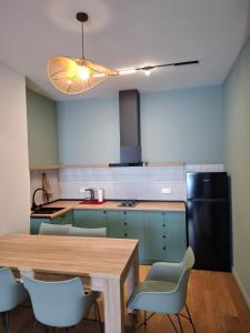 a kitchen with a table and chairs and a refrigerator at New Gudauri Two Bedroom Apartment Neo Building in Gudauri