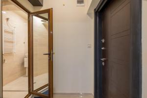 a bathroom with a mirror next to a door at Stylish TOP center Flat 100m to Vitosha blvd in Sofia +25 photos