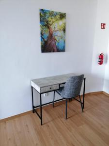 un escritorio con una silla frente a un cuadro en Pôr do Sol I, en Porto Moniz